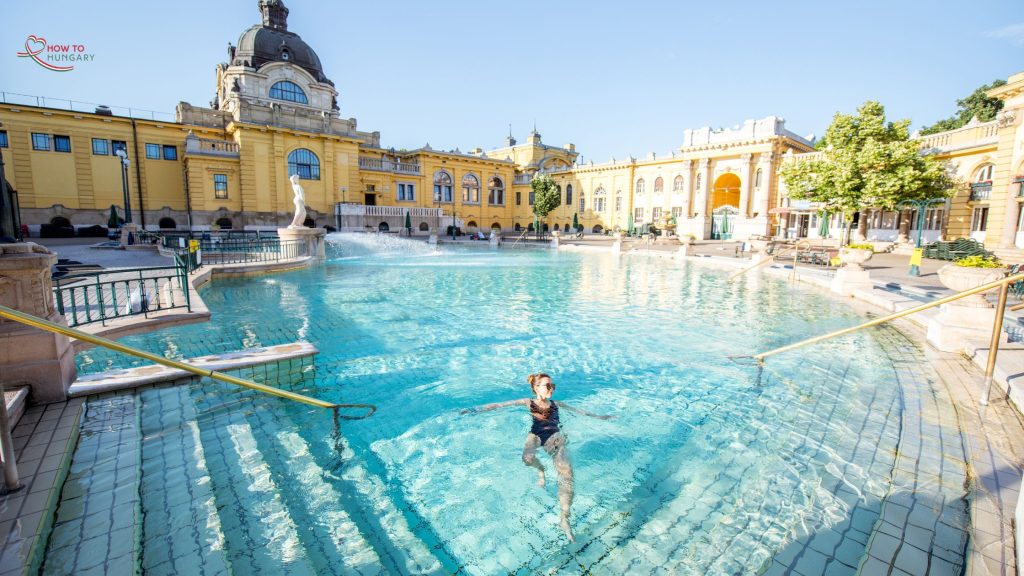 Woman relaxing in the outdoor pool of Széchenyi Thermal Baths in Budapest, Hungary, on a sunny morning. 