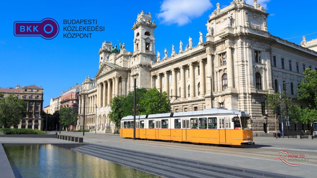 BKK tram on a cobblestone street in Budapest, Hungary, with historic buildings and greenery in the background.