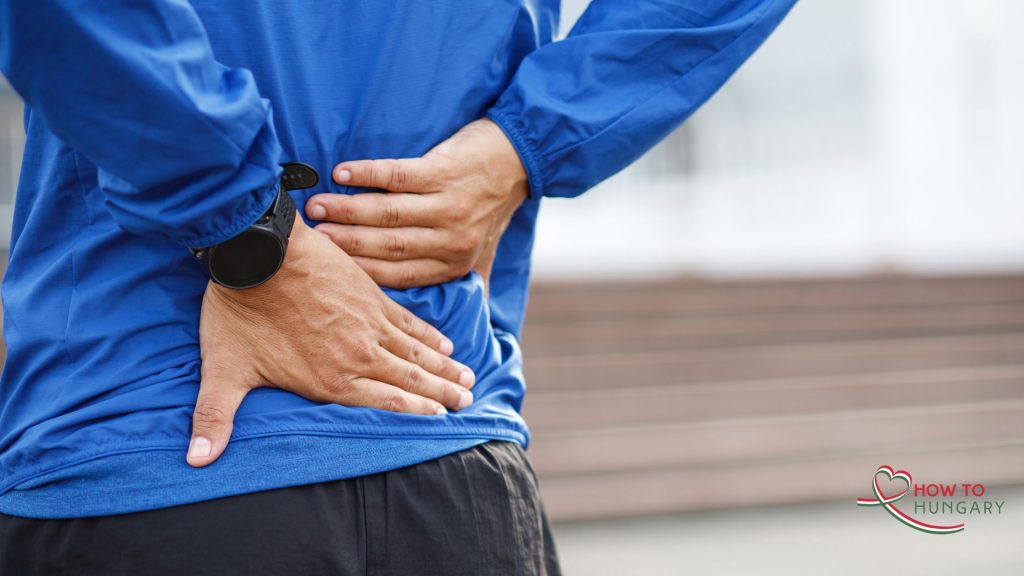 Man holding lower back in pain, Hungary medicine price freeze 2025, Voltaren