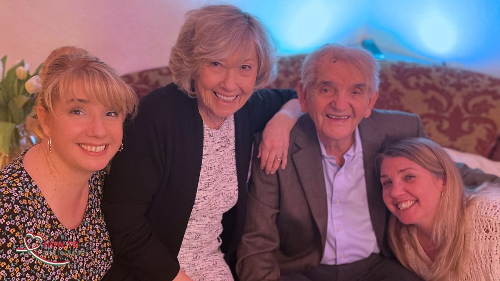 Family photo from our first Christmas back in Hungary in 2021 — me, my parents, and my sister together in a living room glowing pink with Christmas lights, after returning through citizenship by descent.