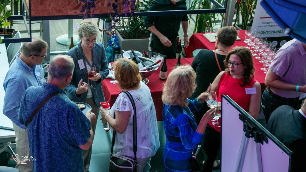 Guests mingling with glasses of Hungarian wine at the sold-out HOW TO HUNGARY September Social, KLUSTER Budapest.