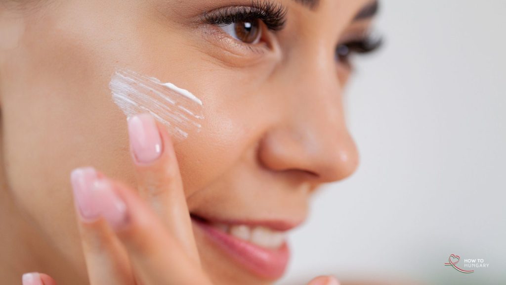 Woman smoothing face cream onto her cheek as part of a Korean skincare routine, from a post about how to start a business in Hungary
